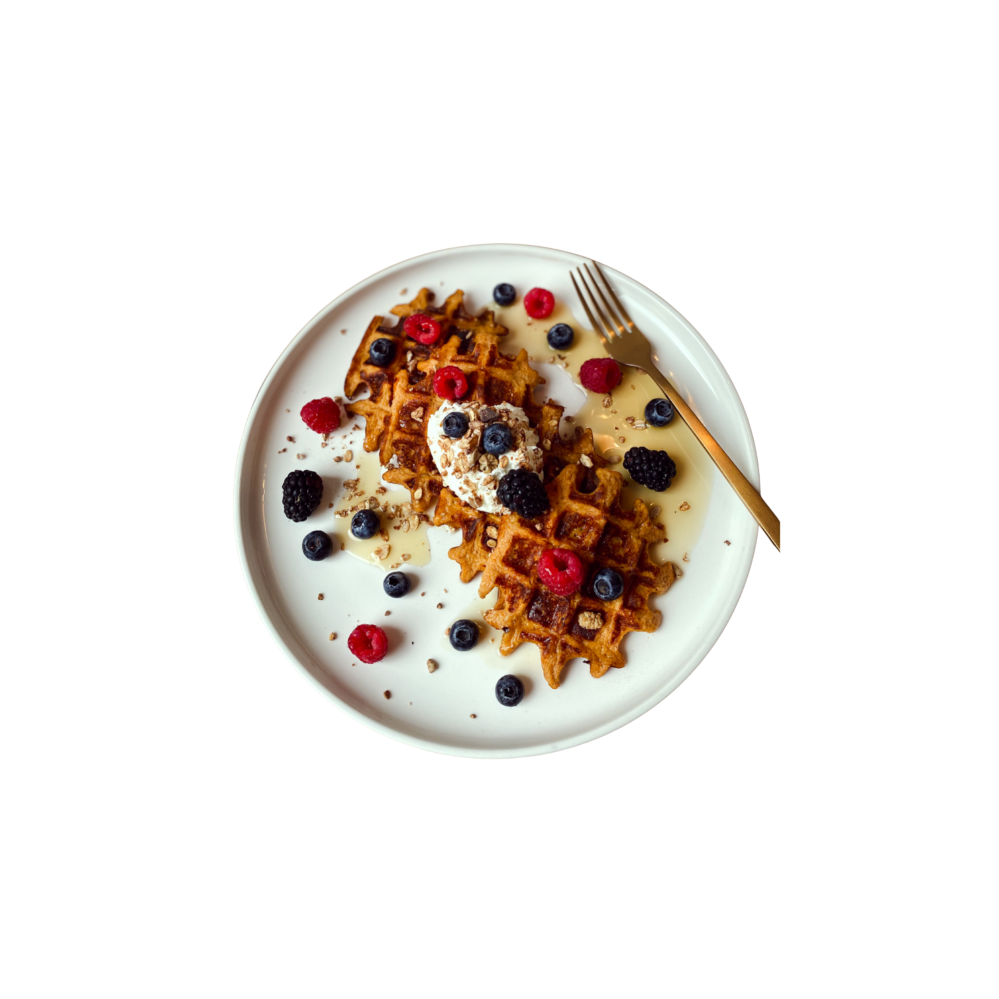 Golden waffles topped with berries, cream, and maple syrup